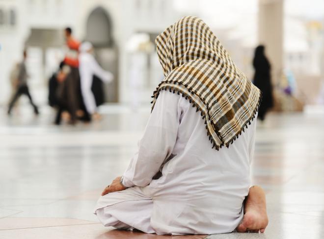 a muslim man praying alone